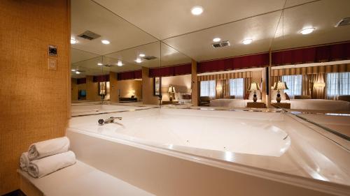 a large bath tub in a bathroom with a large mirror at Best Western Plus Las Brisas Hotel in Palm Springs