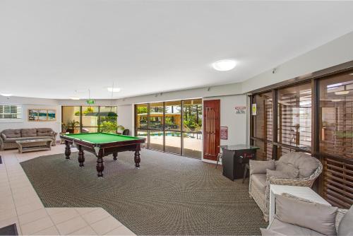 a living room filled with furniture and a pool at Burleigh Esplanade Apartments in Gold Coast