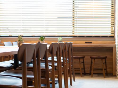 a dining room with a table and chairs and a window at Super Hotel Sendai Airport Inter in Natori