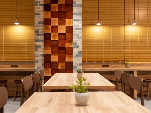 a dining room with wooden tables and chairs at Super Hotel Sendai Airport Inter in Natori
