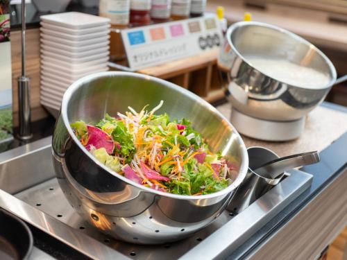 a large pot on a stove with a salad in it at Super Hotel Sendai Airport Inter in Natori
