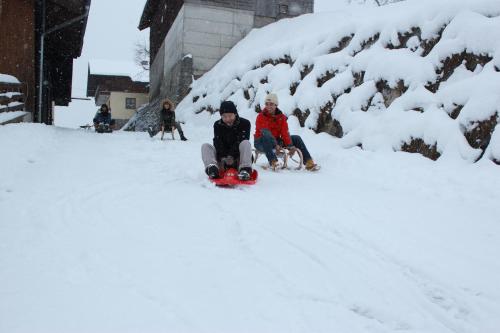 two people sitting on a snowmobile in the snow at Schaidreithof in Grossarl