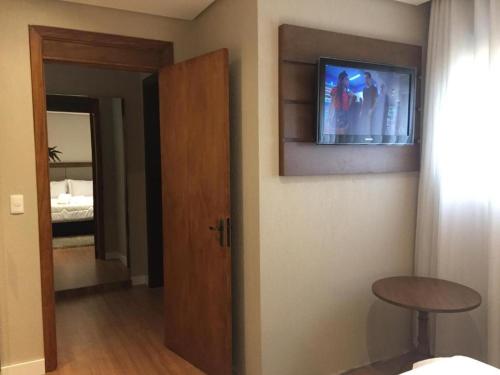 Una televisión o centro de entretenimiento en Apartamento Luxo em Gramado