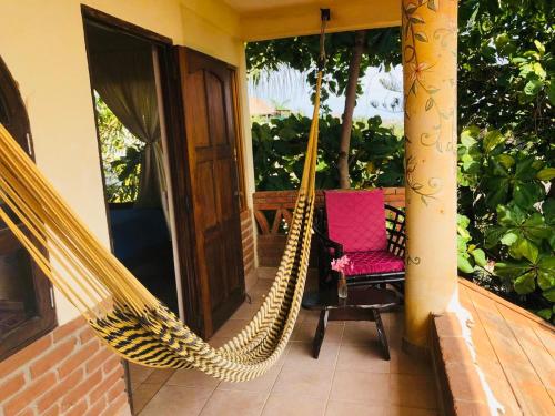 a hammock on the porch of a house at Ananda Guest House Yoga & Meditación in Puerto Escondido