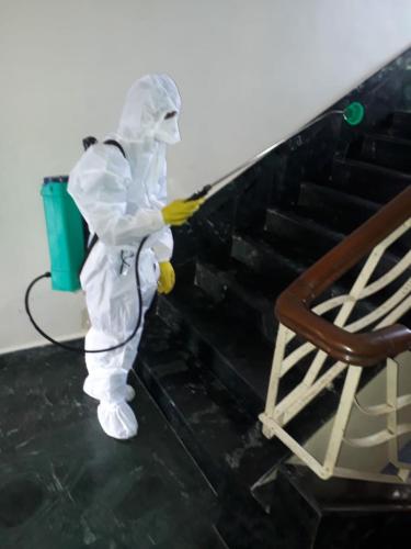 a person in a white suit painting a wall at Hotel Lucky Goregaon in Mumbai