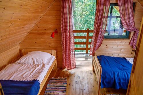 um quarto com 2 camas num chalé de madeira em Pinia em Pobierowo