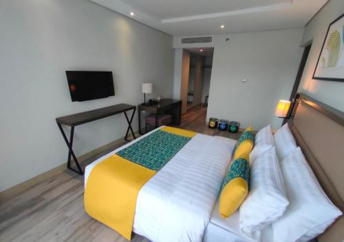 a bedroom with a large bed and a television at Belmont Hotel Boracay near Newcoast Beach in Boracay