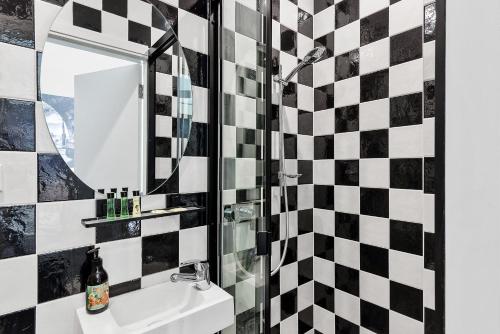 a bathroom with a black and white checkered wall at Criterion Hotel Sydney in Sydney
