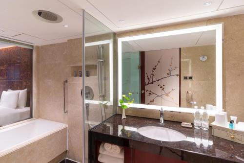 a bathroom with a sink and a large mirror at China Hotel Guangzhou - Subway direct to Pazhou Exhibition Center, Free shuttle during Canton Fair & Exhibitor registration Counter in Guangzhou