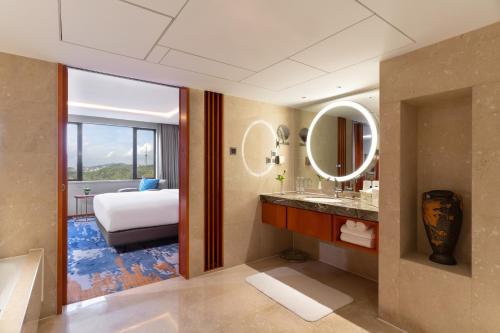 a bathroom with a bedroom with a bed and mirrors at China Hotel Guangzhou - Subway direct to Pazhou Exhibition Center, Free shuttle during Canton Fair & Exhibitor registration Counter in Guangzhou