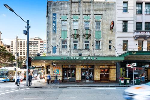 a building on the corner of a city street at Criterion Hotel Sydney in Sydney