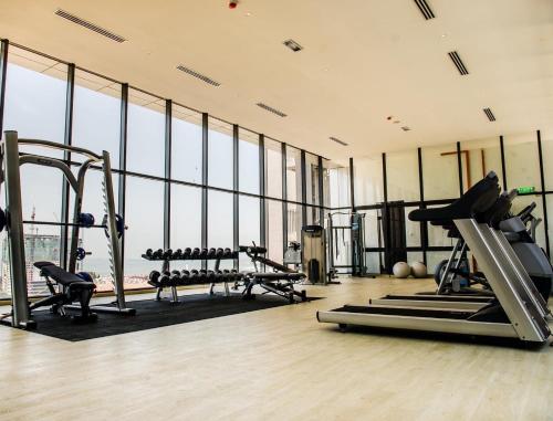 a gym with treadmills and machines in a room with windows at Imperio Residence Bathtub Studio at Malacca Town-Near JONKER STREET in Melaka