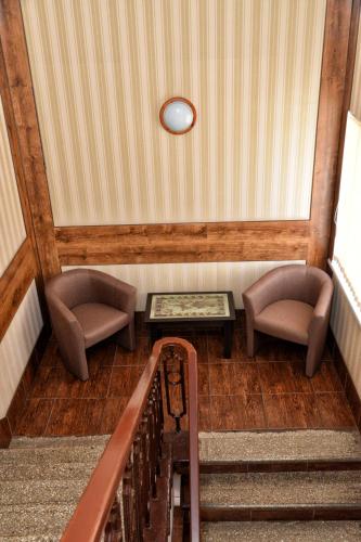 a room with two chairs and a table and stairs at Green City Hotel in Mykolaiv