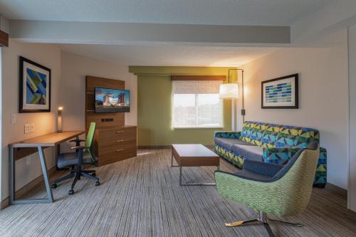 a living room with a couch and a desk at Holiday Inn Express & Suites Asheville Downtown by IHG in Asheville