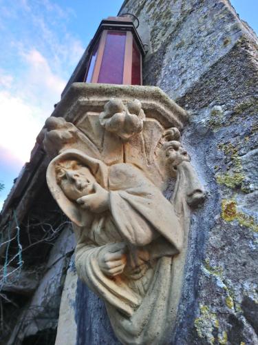 un ange en pierre sur le côté d'un bâtiment dans l'établissement La Mare aux 3 Diables, à Fresney-le-Vieux