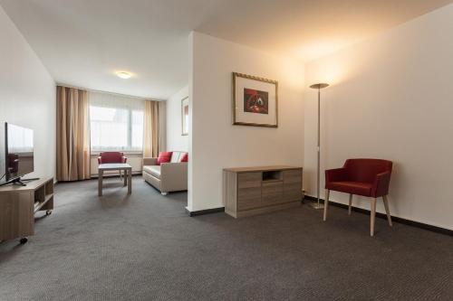 a living room with a couch and a television at EMA House Serviced Apartments Aussersihl in Zürich