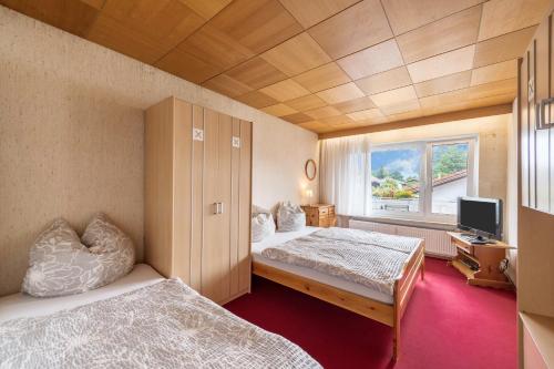 a room with two beds and a television in it at Haus Schild in Grassau