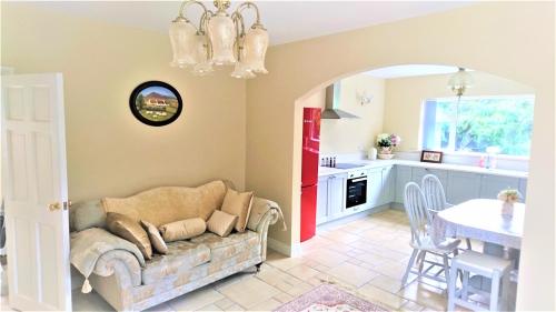 a living room with a couch and a kitchen at Knocknagore Cottage in Gilford