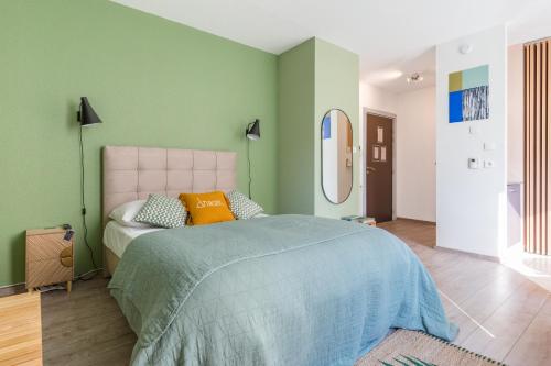 una camera con un grande letto e uno specchio di Travel Homes - Le GreenBay, Adorable et agréable a Mulhouse