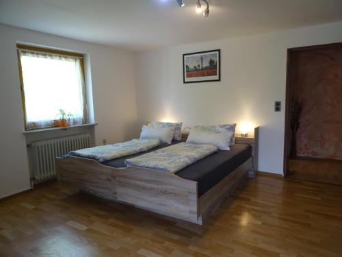 ein Schlafzimmer mit einem Holzbett mit Kissen darauf in der Unterkunft Ferienwohnung Christine Trautner in Gößweinstein
