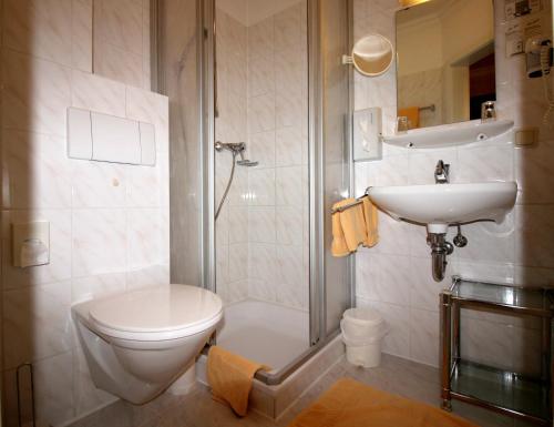 a bathroom with a toilet and a sink and a shower at Hotel-Garni Haus Johanna in Einbeck