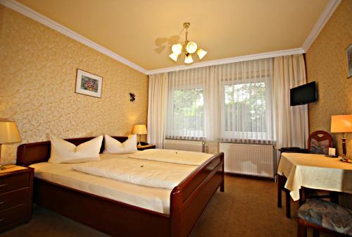 ein Schlafzimmer mit einem großen Bett und einem Fenster in der Unterkunft Hotel-Garni Haus Johanna in Einbeck