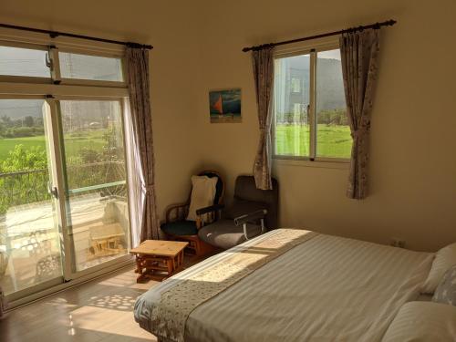 ein Schlafzimmer mit einem Bett und einem großen Fenster in der Unterkunft Home-Link B&B in Fenglin