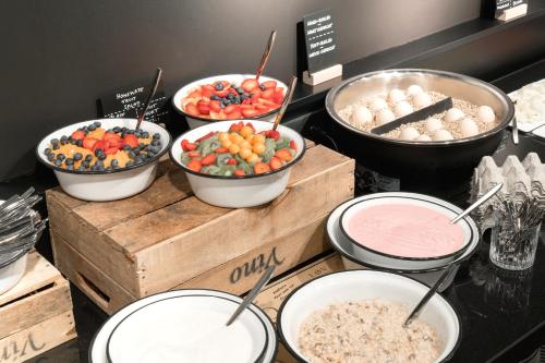 a buffet with bowls of food on a table at Ruby Coco Hotel Dusseldorf in Düsseldorf