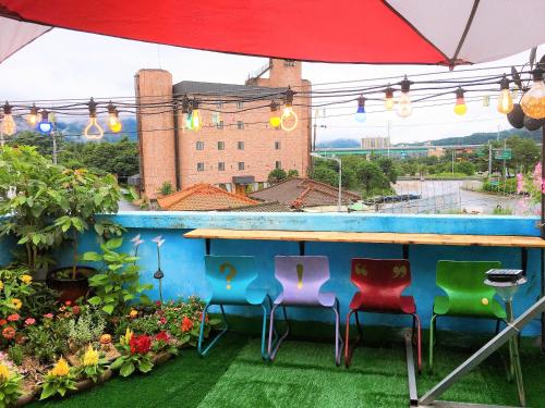 a bar on a balcony with chairs and flowers at Jarasum Guest House in Gapyeong