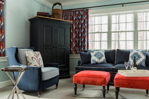 a living room with a blue couch and a red stool at The Inn at Hastings Park, Relais & Châteaux in Lexington