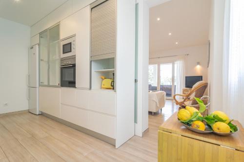 a kitchen with a counter and a bowl of fruit on a table at Cala Llonga in Santanyi