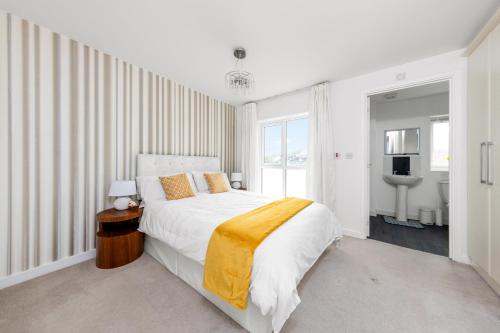 a white bedroom with a large bed and a bathroom at Royal House Wolverhampton - Perfect for Contractors & Large Groups in Wolverhampton