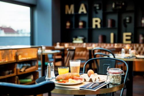 a table with a plate of food and drinks at Ruby Marie Hotel Vienna in Vienna