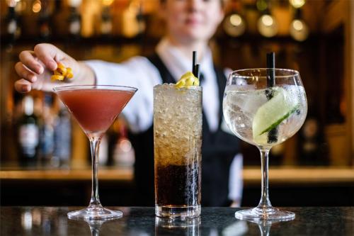 three cocktails sitting on a table in a bar at Moor Hall Hotel & Spa in Sutton Coldfield