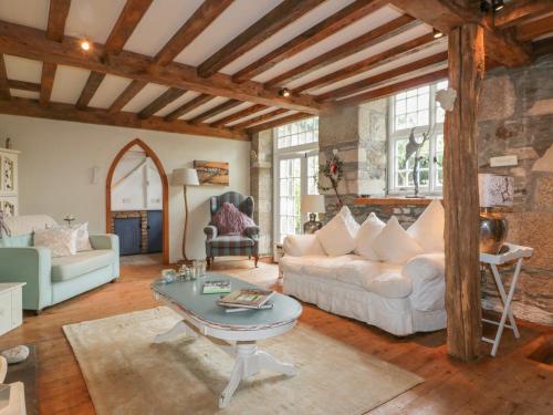 a living room with a white couch and a table at Coinage Hall in Lostwithiel