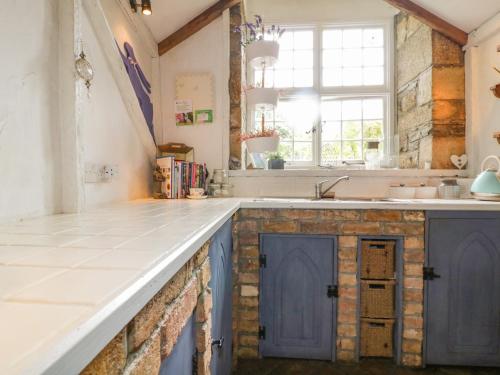 a kitchen with blue cabinets and a sink at Coinage Hall in Lostwithiel