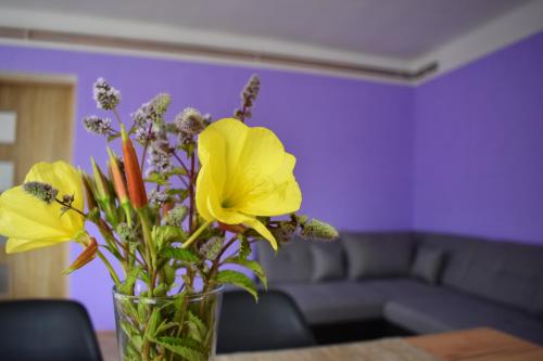 a vase filled with yellow flowers on a table at PENZION a FARMA NA BORŮVKOVÉM VRŠKU in Bujanov