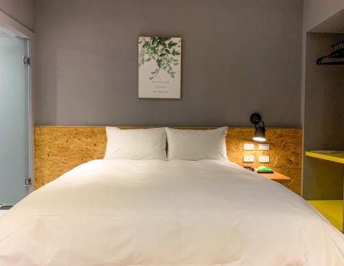 a large white bed in a room with at Raise Hotel Taichung in Taichung