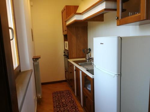 a small kitchen with a refrigerator and a sink at Apt Alice - Apartment in the Vineyards in Strada
