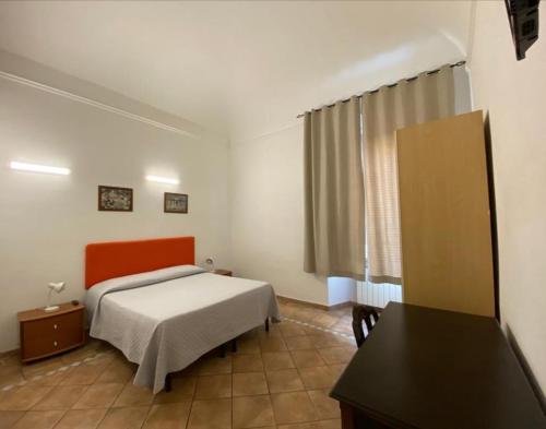 a bedroom with a bed and a desk in it at Hotel Il Papavero in Rome