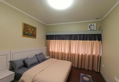 a bedroom with a bed and a window at Zarania Hillhomes in Cameron Highlands