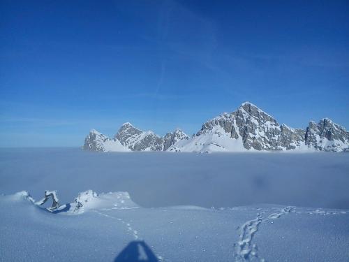a snow covered mountain range with footprints in the snow at Ferienwohnung Schautzgy in Reutte