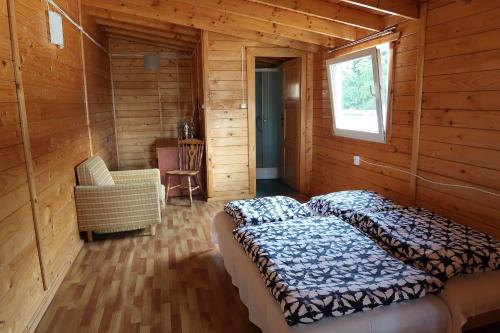 a bedroom with a bed in a wooden cabin at Bohema Osada in Łazy