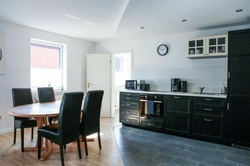 a kitchen with a wooden table and chairs and a kitchen with a counter at Apartment "New York" in Korschenbroich