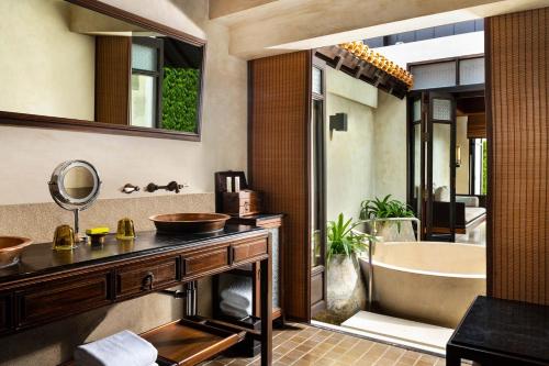 uma casa de banho com uma banheira e um lavatório e uma banheira em The Lamai Samui em Lamai