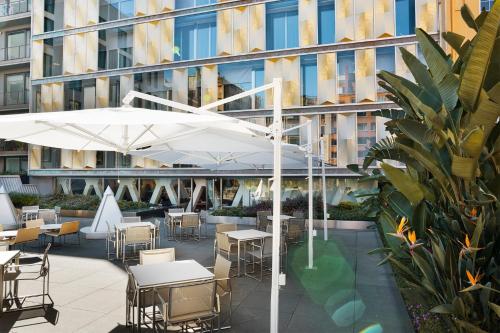 a patio with tables and chairs and an umbrella at Hotel Royal Passeig de Gracia in Barcelona