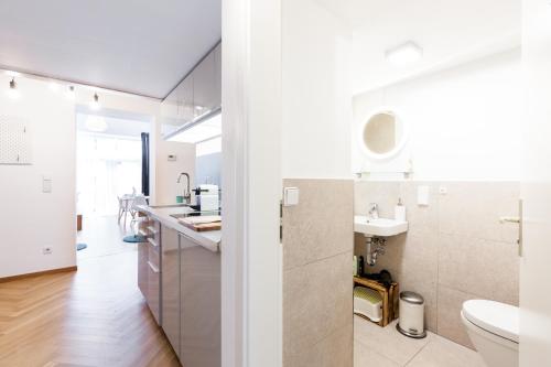 a white bathroom with a sink and a toilet at DR Apartments Prenzlauer Berg in Berlin
