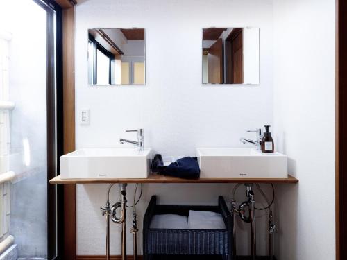 een badkamer met twee wastafels en twee spiegels bij Connect inn Gion-Bishamoncho in Kyoto