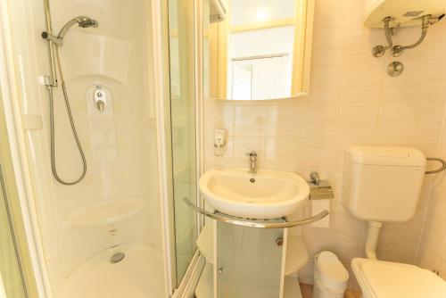 a bathroom with a sink and a toilet and a shower at Apartments Villa Devana 2 in Opatija