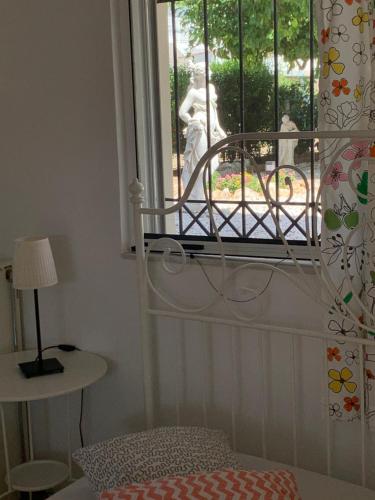 a bedroom with a bed and a window with a statue at Best location in Vrachati in Vrahati